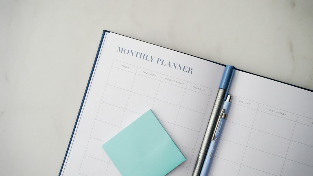 An open monthly planner with a pen and sticky note, representing long-term cycle planning