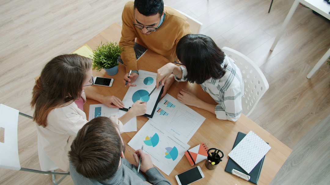 Four advisory committee members reviewing charts together around a table