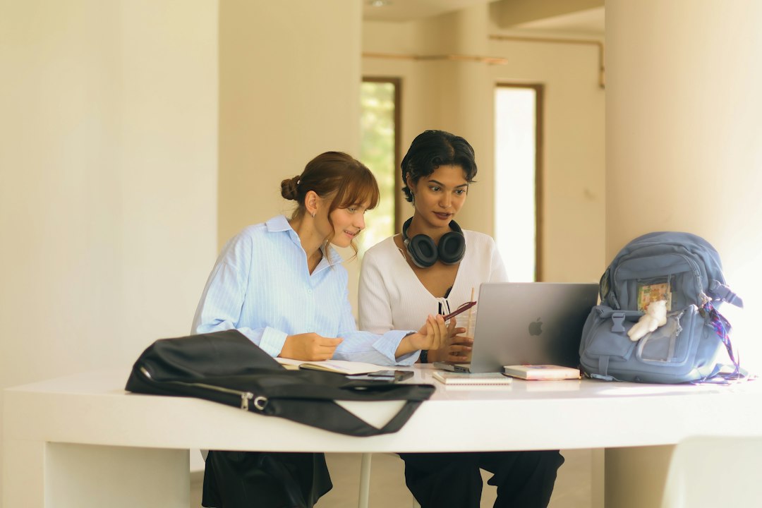Two students reviewing program information together on a laptop