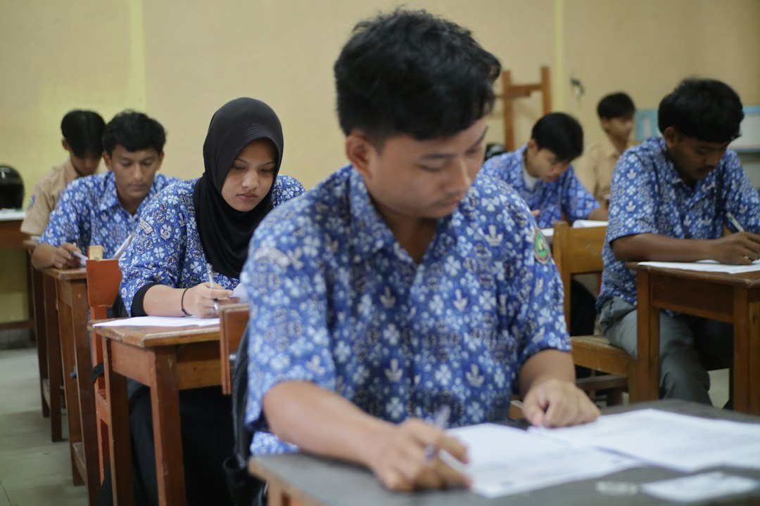 Students seated at desks taking a written exam in a classroom