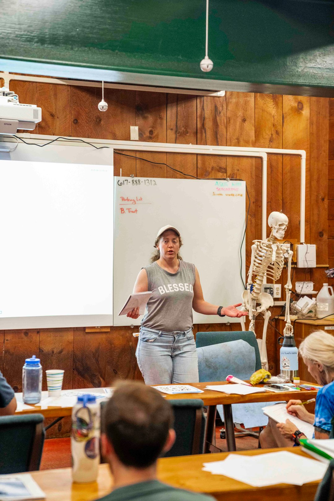 A health-science instructor presenting in a classroom with an anatomy model