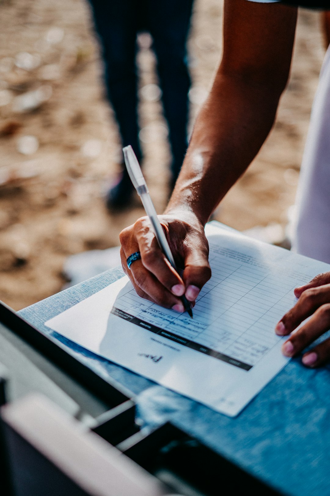 A person filling in a paper survey form with a pen