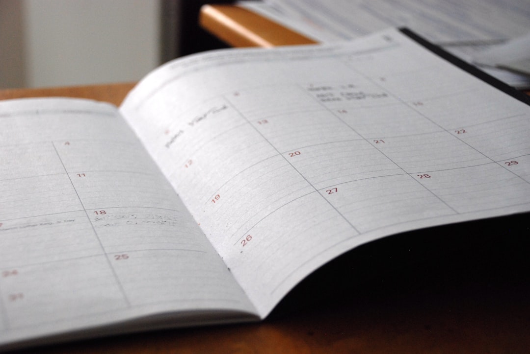 Open monthly planner on a wooden desk, representing the CAAHEP board meeting calendar