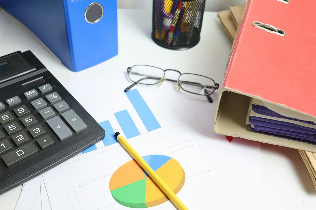 A desk with calculator, charts, and binders — the report's data scattered across systems