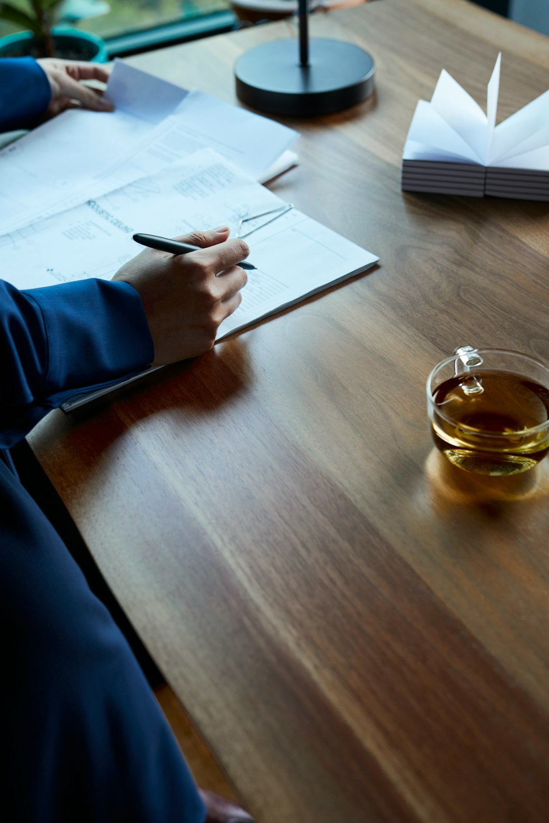 A program director writing up a report at a meeting table