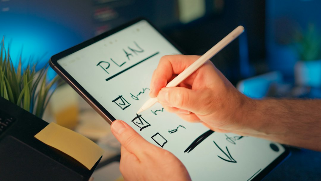 Hand writing a plan with checkboxes on a tablet