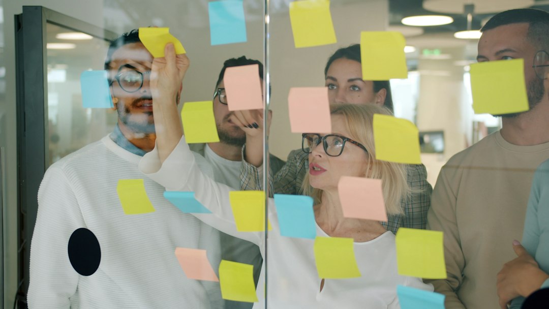 A team tracking progress on a wall of sticky notes